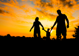 Child walking in between mother and father.