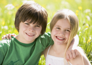 Little boy and little girl with arms around each other.