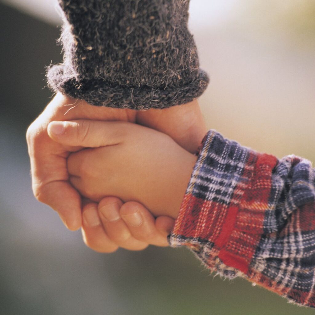 Father holding child's hand.